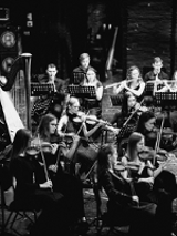Black and white photo of the orchestra performing on stage.