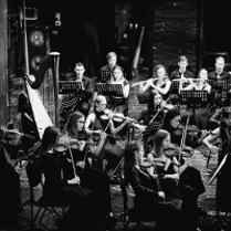 Black and white photo of the orchestra performing on stage.
