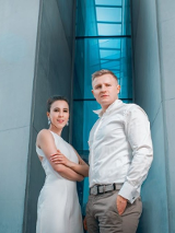 Photo of the performers: a man and a woman in front of the building