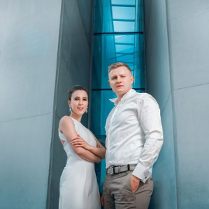 Photo of the performers: a man and a woman in front of the building