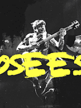 Concert poster - yellow inscription - the name of the band on black and white photo of a man with a guitar