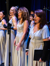 Photo of women singing on stage.