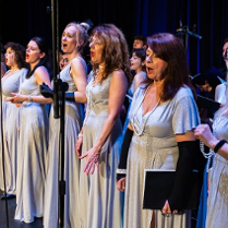 Photo of women singing on stage.