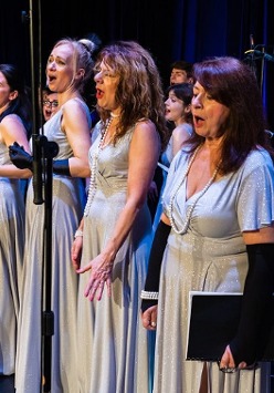 Photo of women singing on stage.