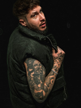 Photo of the young man with numerous tattoos on his arm.