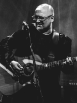 Black and white photo of the artist - Robert Kasprzycki playing the guitar