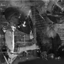 Black and white photo of two musicians by their musical instruments.