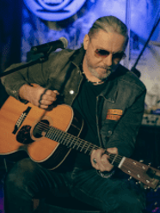 Photo of Sebastian Riedel playing the guitar.