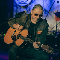 Photo of Sebastian Riedel playing the guitar.