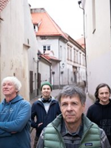 Photo of the band's members on a narrow street.
