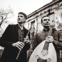 Black and white photo of the performers- two men holding their musical instruments.