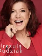 Photo of smiling Urszula Dudziak in red clothes on red background.