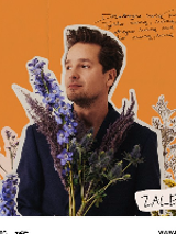 Picture of the artist among flowers on orange background.