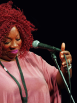 Photo of the artist - a woman by the microphone