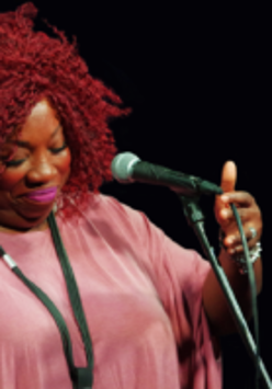 Photo of the artist - a woman by the microphone