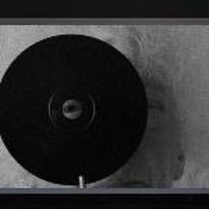 Black and white picture of an elderly woman with gray hair, looking through the hole in a black circle