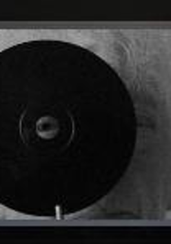 Black and white picture of an elderly woman with gray hair, looking through the hole in a black circle