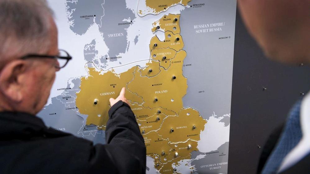 Photo of a man who points a point on a map from the period of the 1st World War