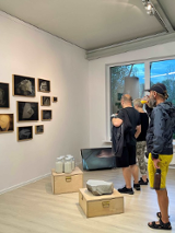 Photo of people watching pictures in a gallery room.