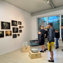 Photo of people watching pictures in a gallery room.