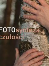 Fragment of a tree embraced by humans hands. In the middle the exhibition title.