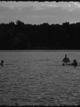 One of the exhibition works - black and white picture of a few people in a lake or river.