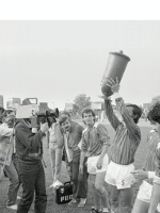 Exhibition poster - black and white photo of the football players, one of them holding a trophy.