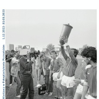 Exhibition poster - black and white photo of the football players, one of them holding a trophy.