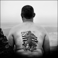 Black and white photo of a man's tattooed back.