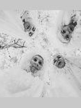 Black and white photo taken from below. 4 people in white costumes