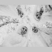 Black and white photo taken from below. 4 people in white costumes