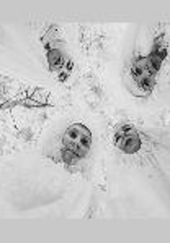 Black and white photo taken from below. 4 people in white costumes