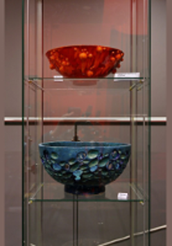 Photo from the exhibition: two vases in a glass case.