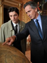 Photo from the movie: two men standing at the globe, one of them is showing something on the globe.
