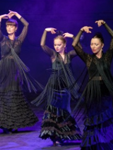 Picture of three flamenco dancers in black dresses; violet background