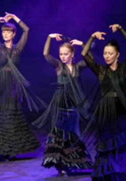 Picture of three flamenco dancers in black dresses; violet background