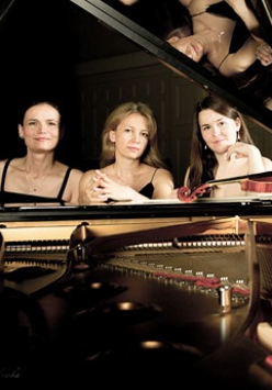 Picture of three women sitting at the grand piano