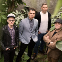 Picture of the band - four men standing and looking up at the camera