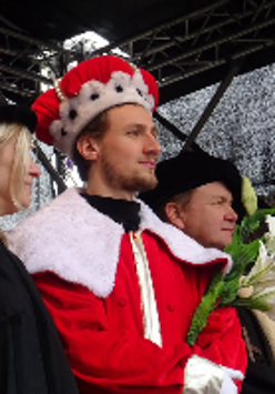 Photo from former celebrations of Kaziuk Wileński - a man in regal gowns holding flowers.