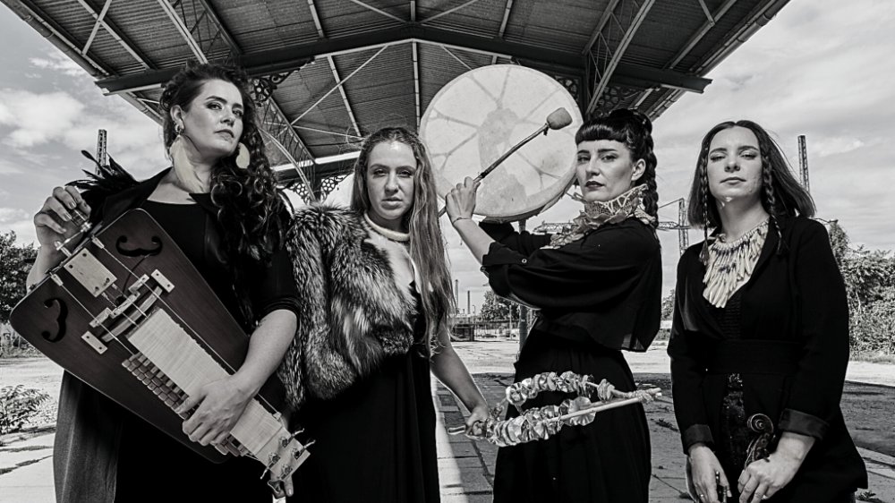 Black and white photo of four women holding musical instruments.