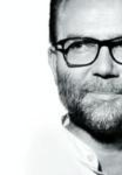 Black and white photo of the artist - the face of a man in glasses