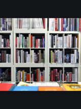 Photo of white bookshelf filled with books.