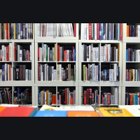 Photo of white bookshelf filled with books.