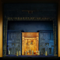 Photo from the performance "Aida": performes on stage, big golden gate as a background.