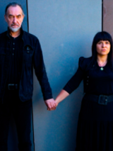 Photo of the artists - a man and a woman holding their hands