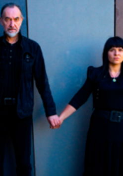 Photo of the artists - a man and a woman holding their hands