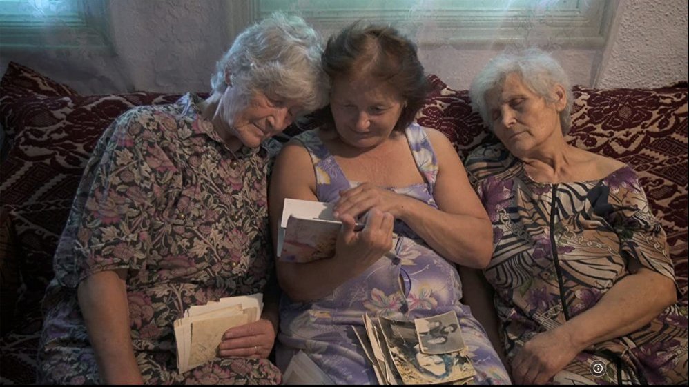 Photo from the movie - three eldery women sitting an a coach. One seems to be sleeping, the other two are looking through some letters.