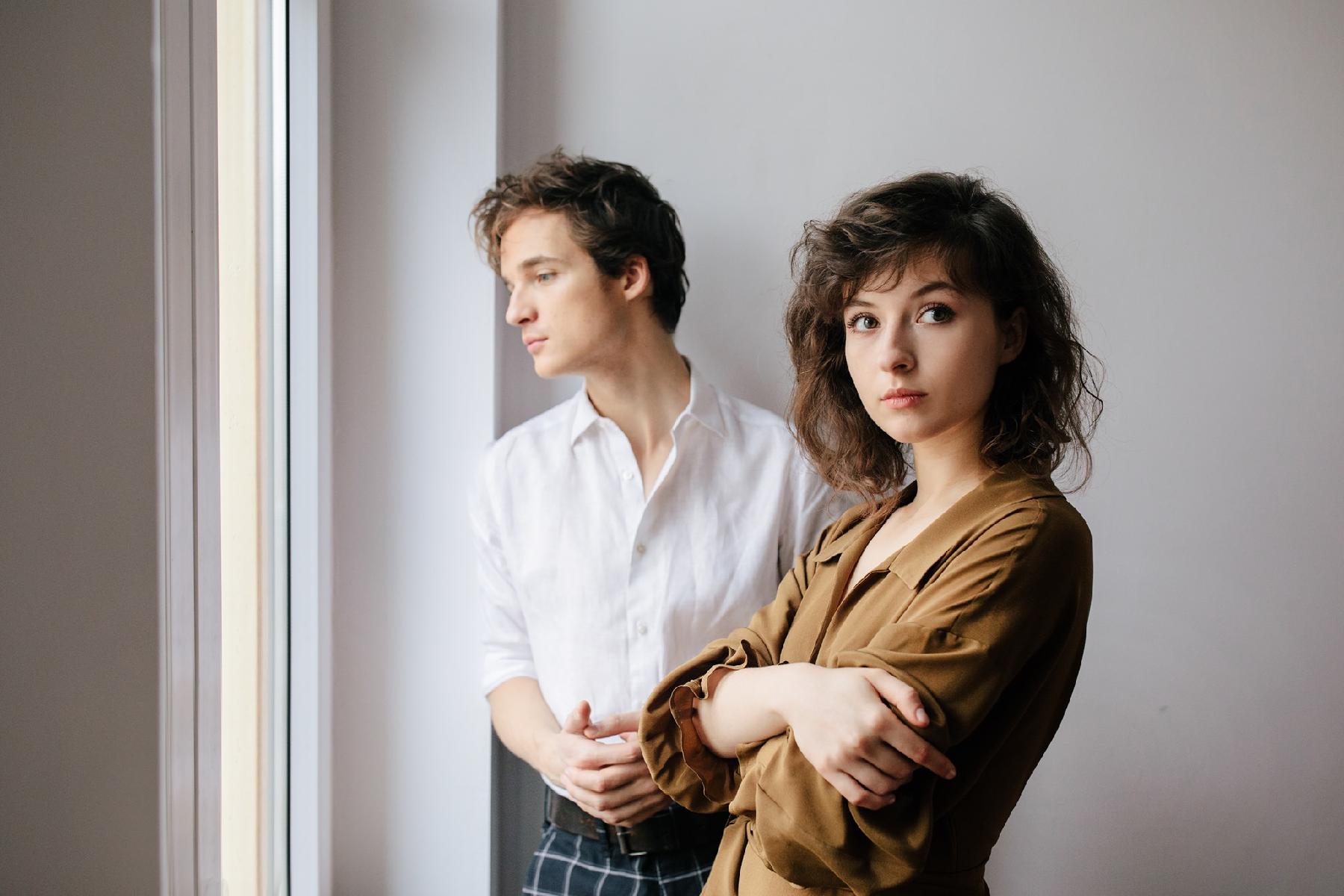 Picture of Kwiat Jabłoni band. A young woman looking at the camera, behind her a man in white shirt looking out of the window - grafika artykułu