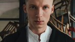 Photo of Igor Herbut, the vocalist of LemON band. A young man in white shirt and dark jacket looking at the camera