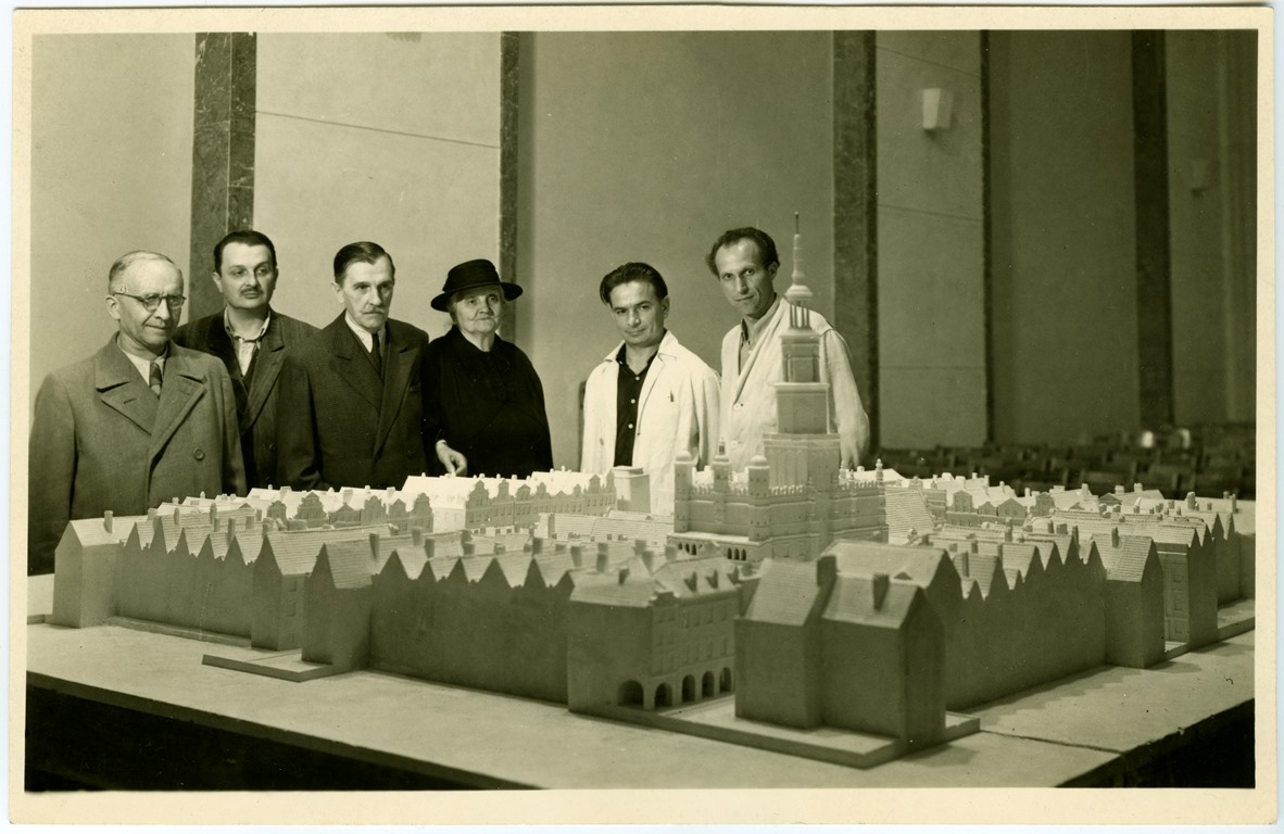 Photo of the Old Market Square mock-up. Behind the mock-up 6 people standing and looking at it. - grafika artykułu